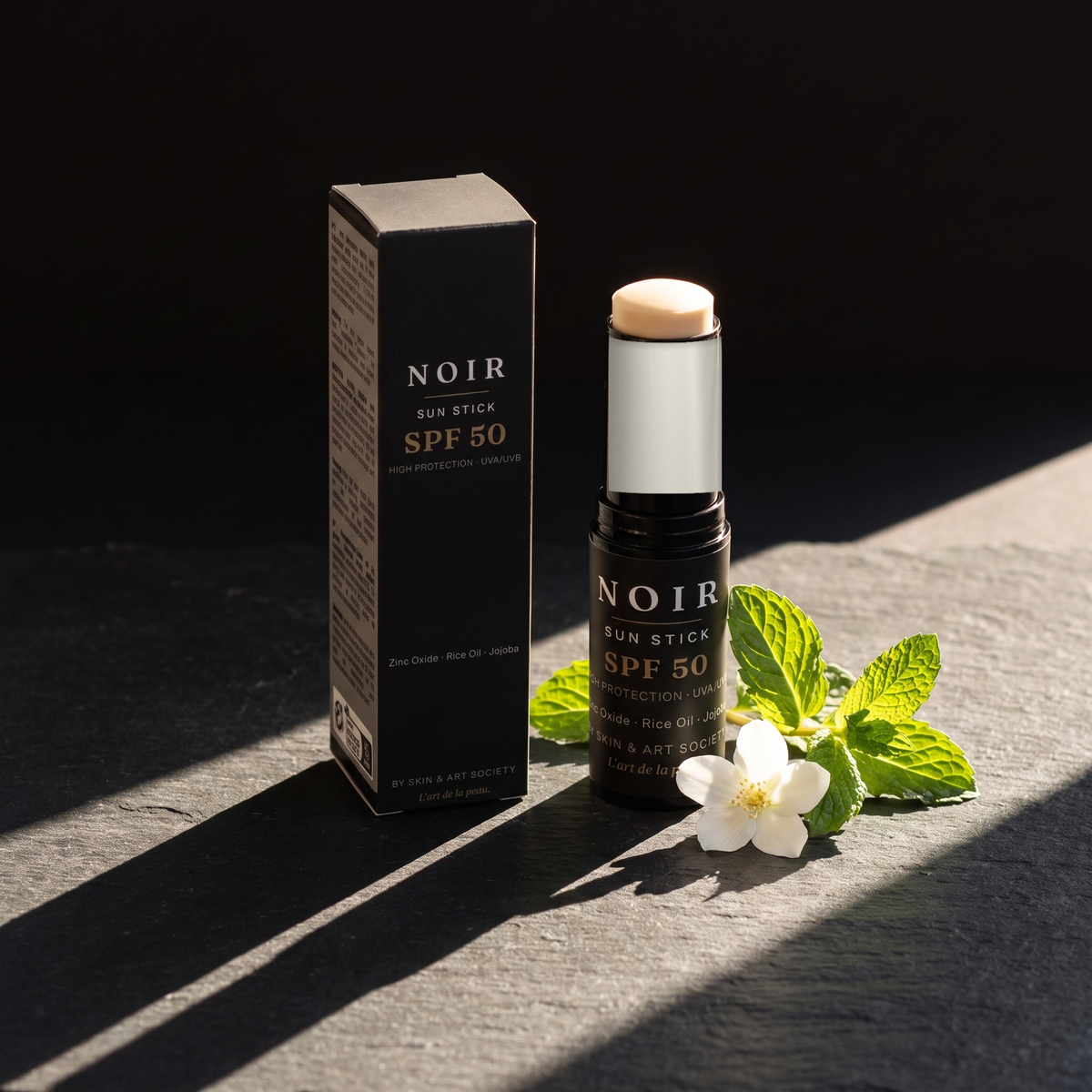 NOIR Sun Stick SPF 50 — Sonne auf Schiefer, Minze und weiße Blüte